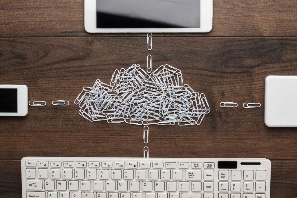 Keyboard and devices connected by paperclips in shape of a cloud