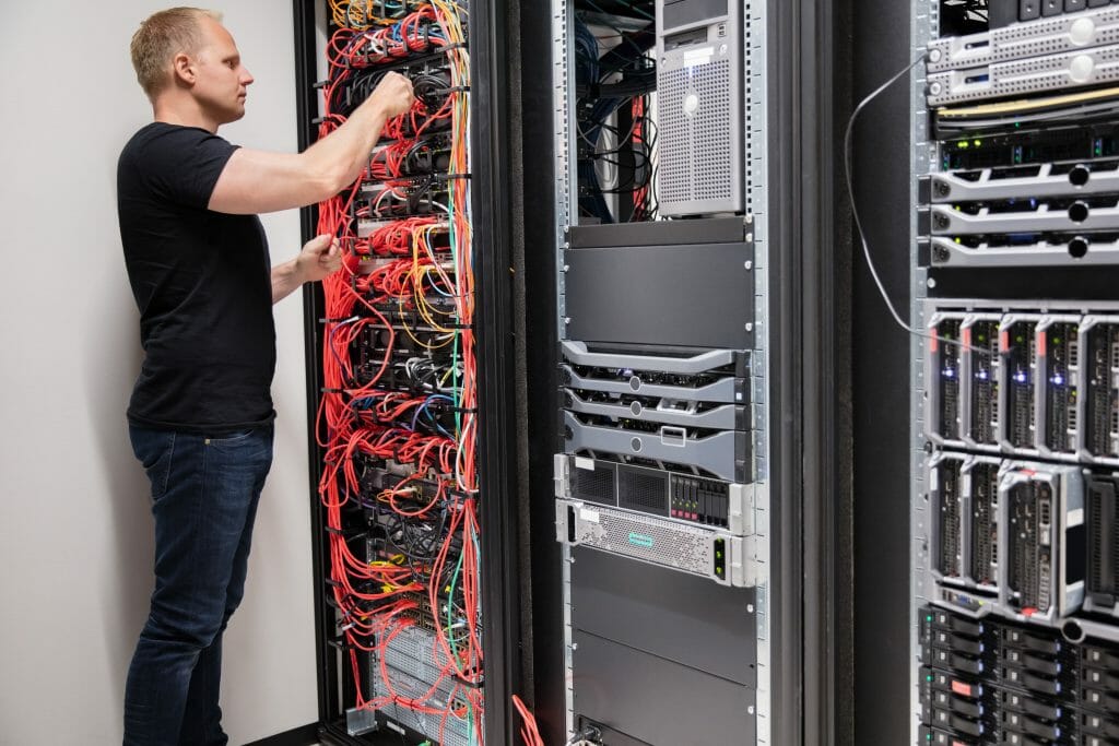IT technician checking wiring of a server