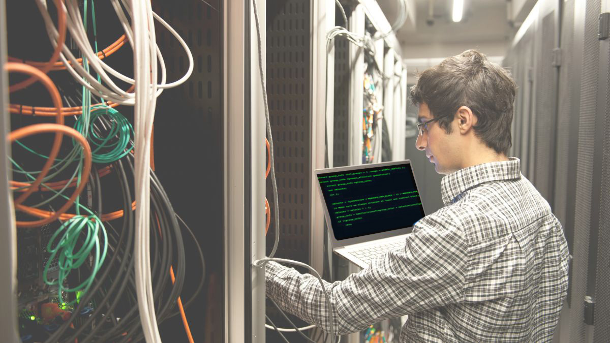 Systems engineer in server room running network scan